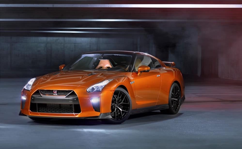 Nissan GT-R orange de trois quarts avant dans un tunnel sombre