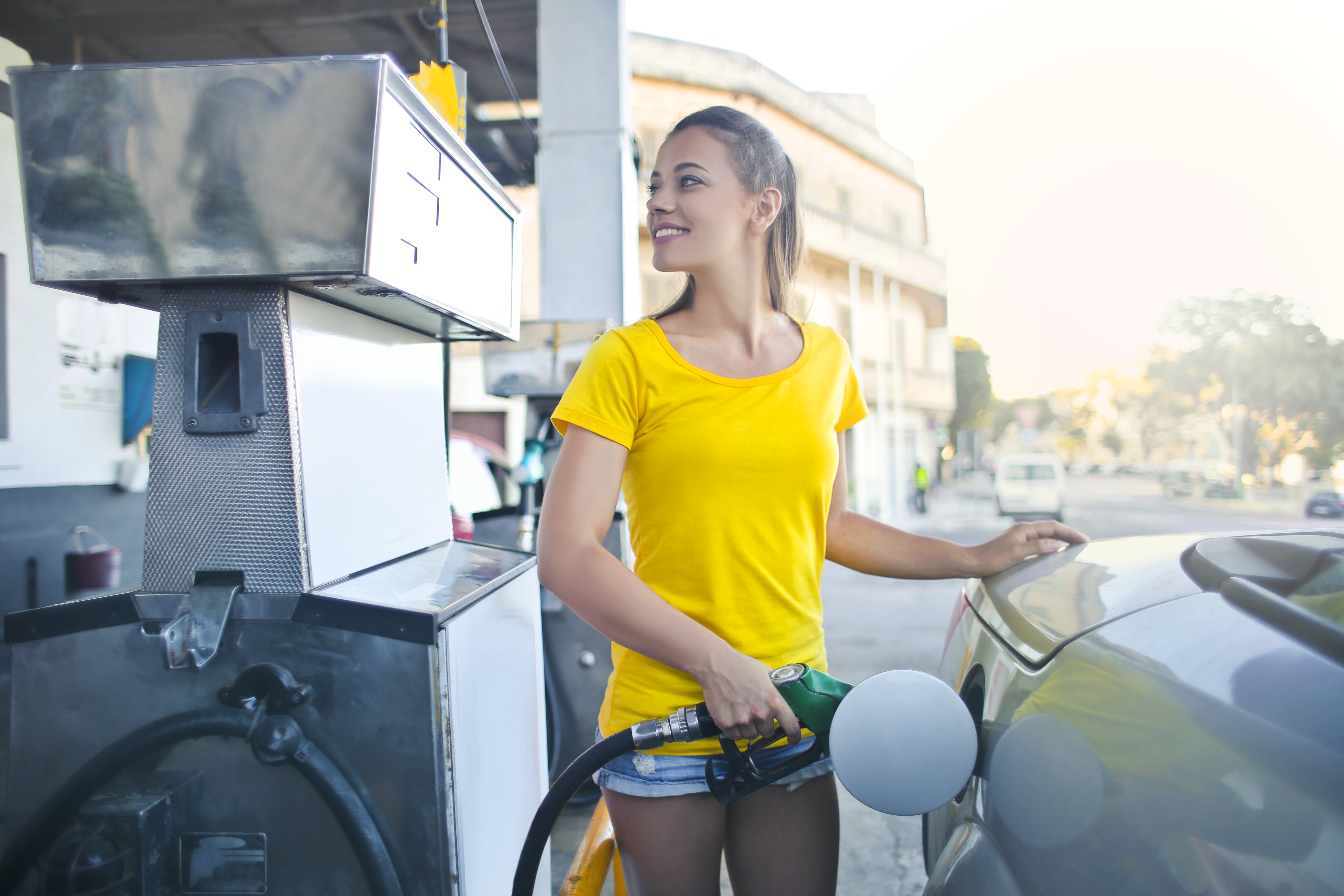 Jeune femme faisant le plein à une station-service